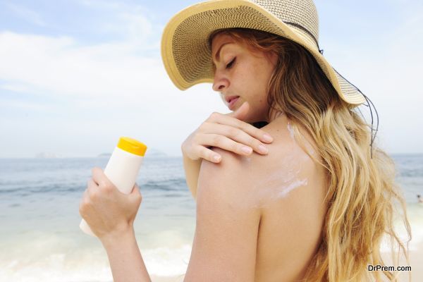 woman applying suntan lotion at the beach